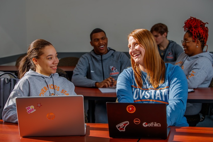 GovState students talking and typing on laptops GovState students talking and typing on laptops